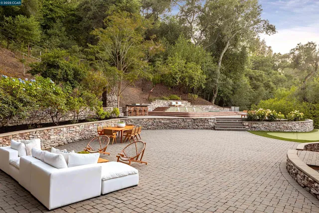 an aerial view of a house with swimming pool and mountains