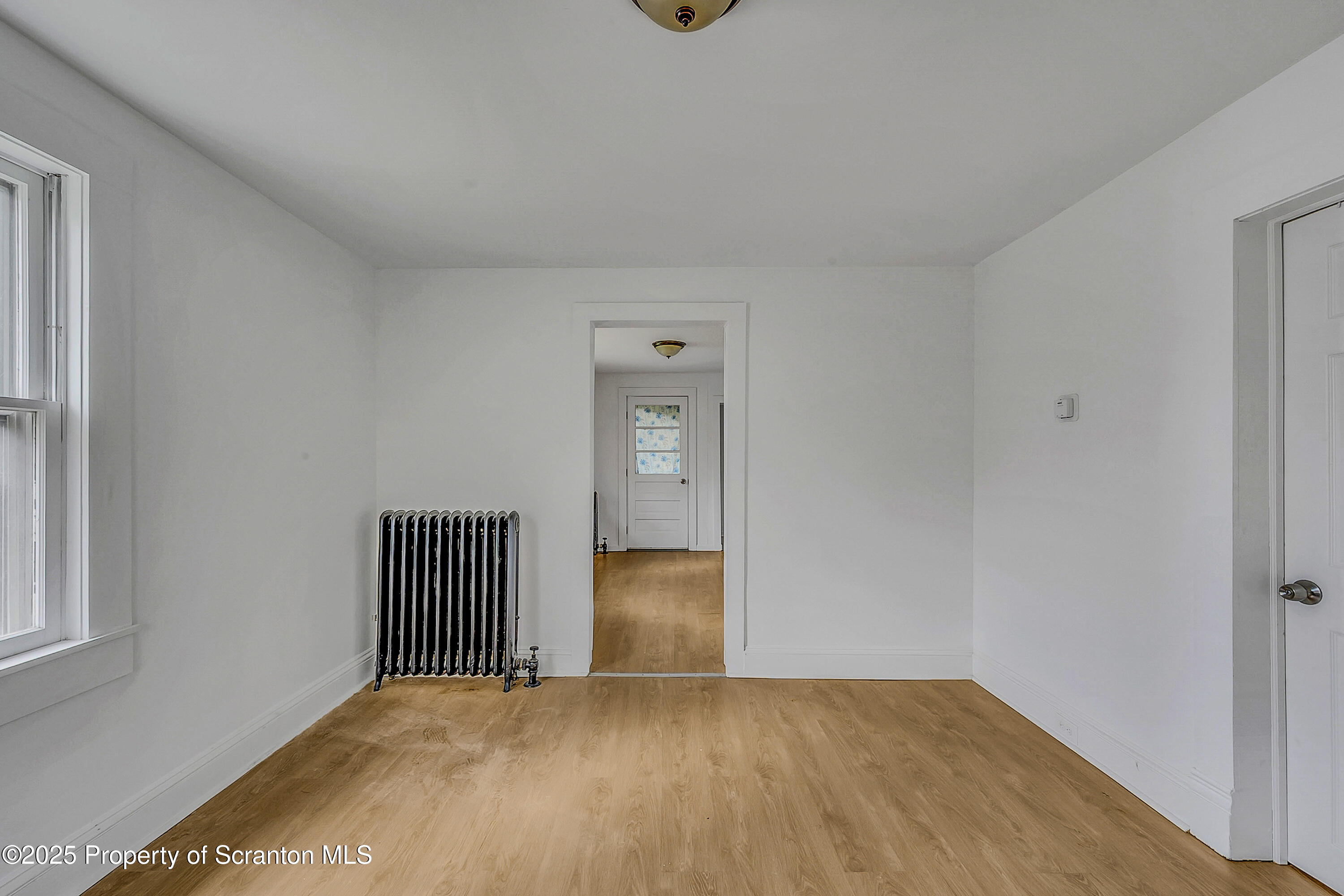 1005 Luke Avenue Scranton, PA 18510 - Photo 5 of 15 a view of an empty room with wooden floor and a window