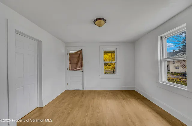 a view of empty room with window and ceiling fan