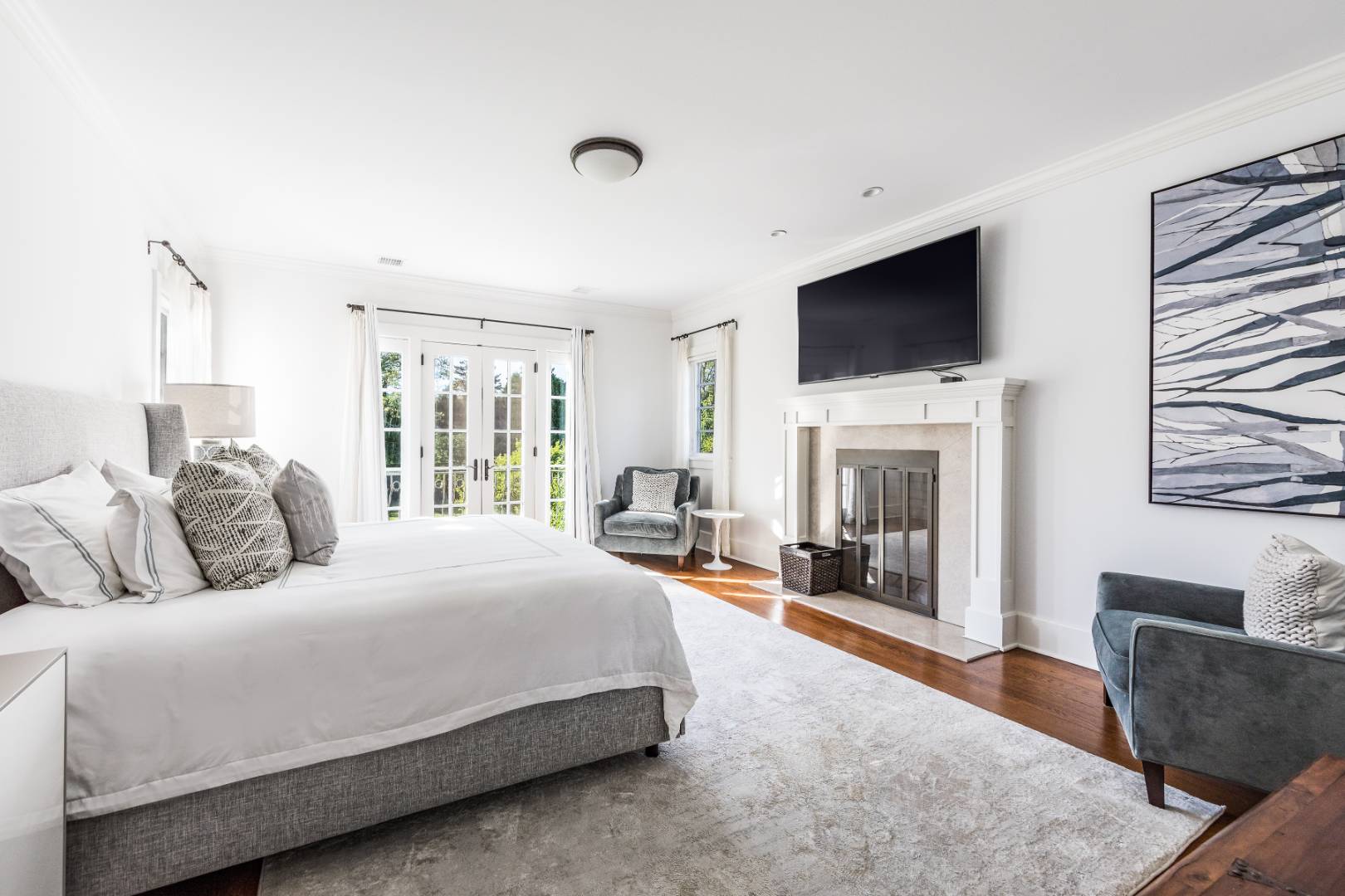 181 Georgica Road East Hampton, NY 11937 - Photo 22 of 38 a spacious bedroom with a bed and a flat screen tv