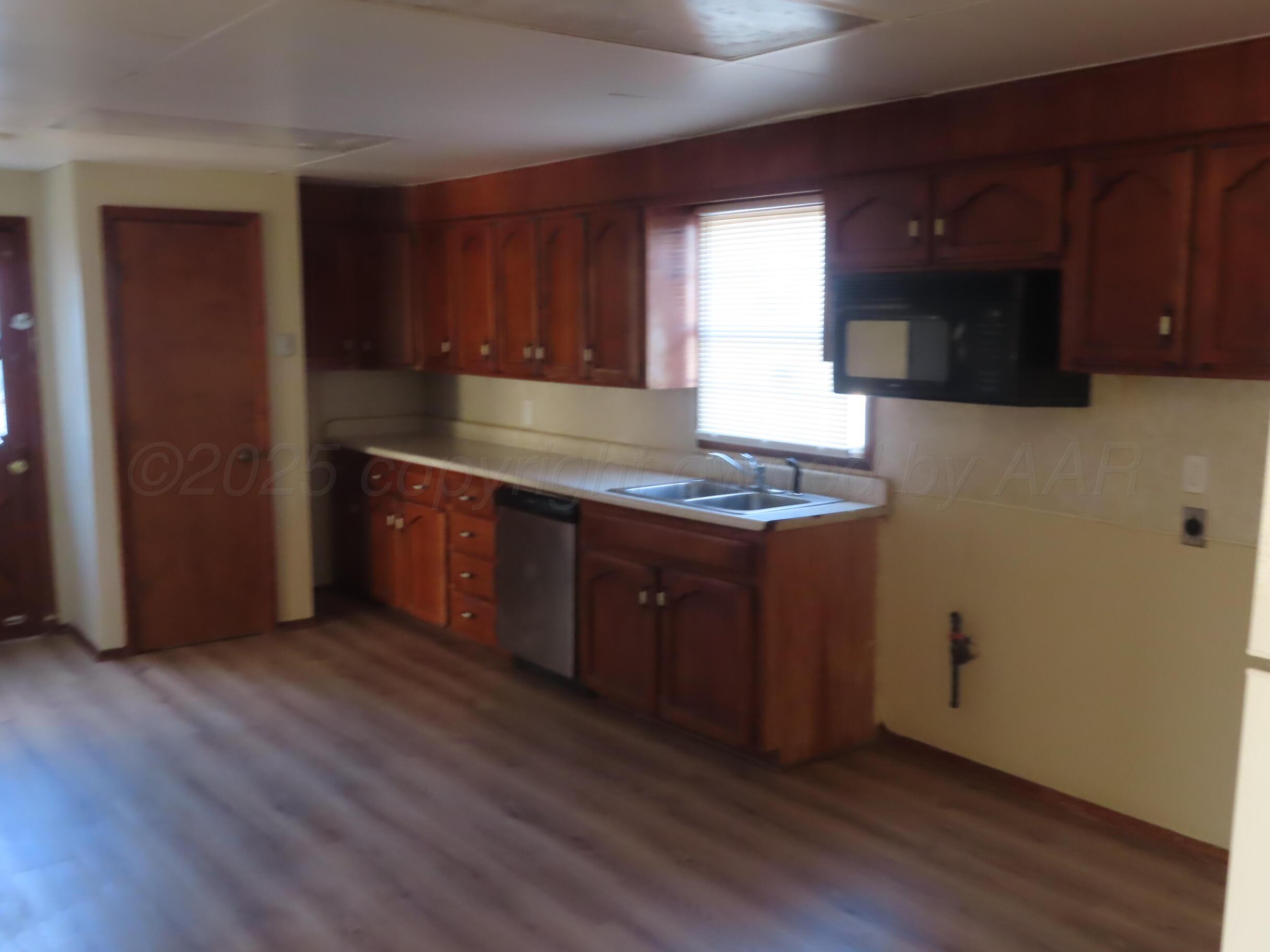2500 Chestnut Street Amarillo, TX 79107 - Photo 3 of 8 a kitchen with stainless steel appliances granite countertop a sink a stove a refrigerator cabinets and wooden floor