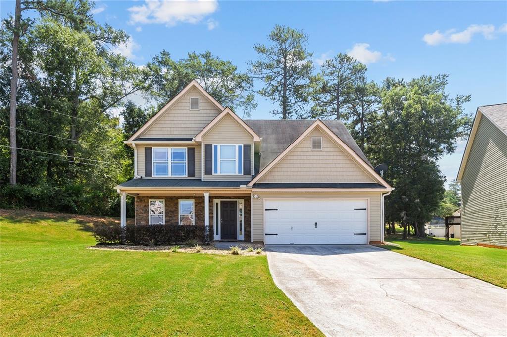 a front view of a house with yard and green space