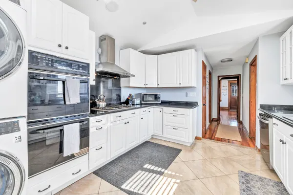 a kitchen with granite countertop a stove top oven sink and cabinets