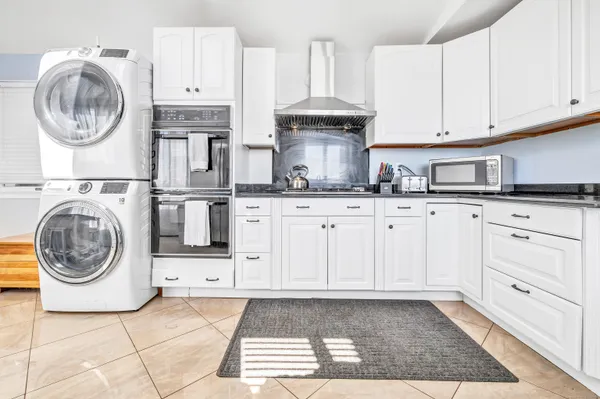 a kitchen with granite countertop a sink a stove and cabinets
