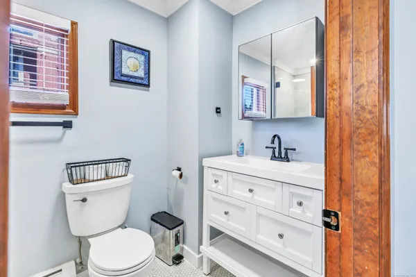 a bathroom with a toilet sink vanity and mirror