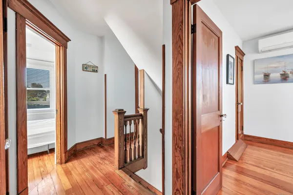 a view of a hallway with wooden floor and staircase