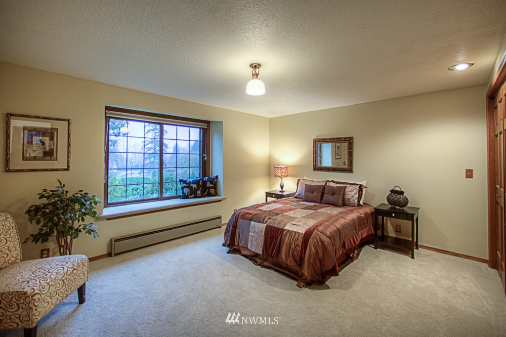 310 208th Street Southeast Bothell, WA 98012 - Photo 12 of 25 a spacious bedroom with a bed and a chandelier