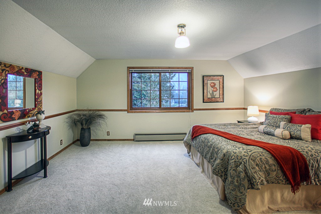 310 208th Street Southeast Bothell, WA 98012 - Photo 14 of 25 a bedroom with a bed and a flat tv screen on the dresser