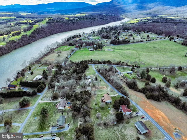 an aerial view of a house with a yard and lake view