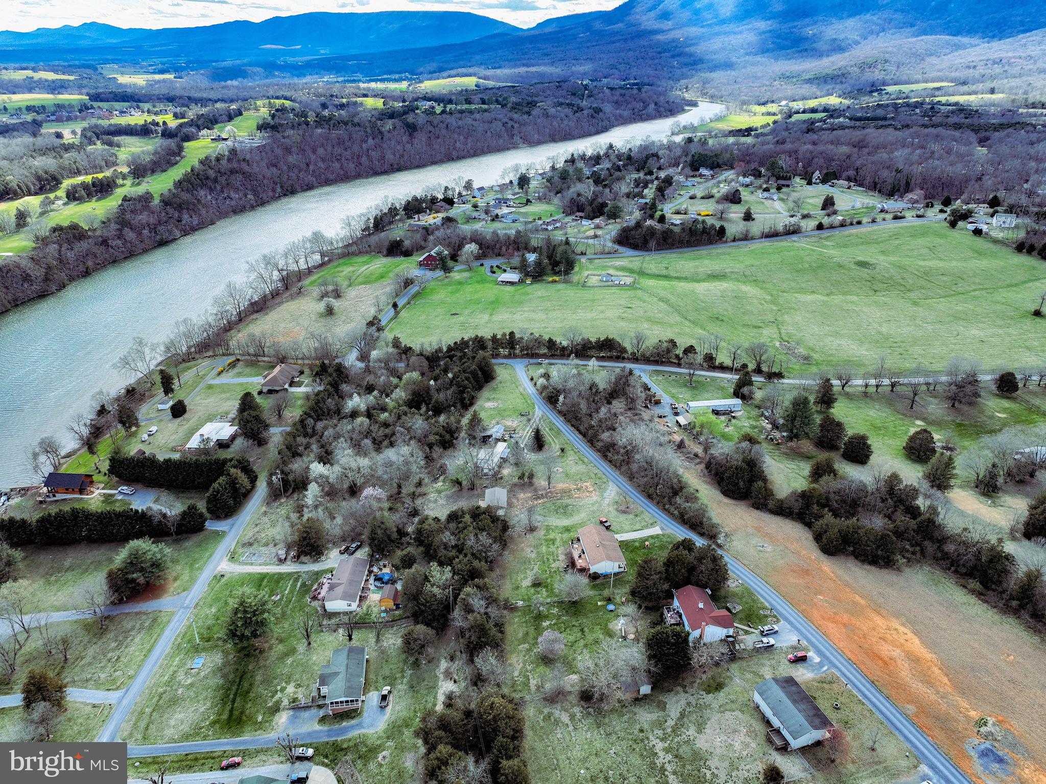 an aerial view of a house with a yard and lake view