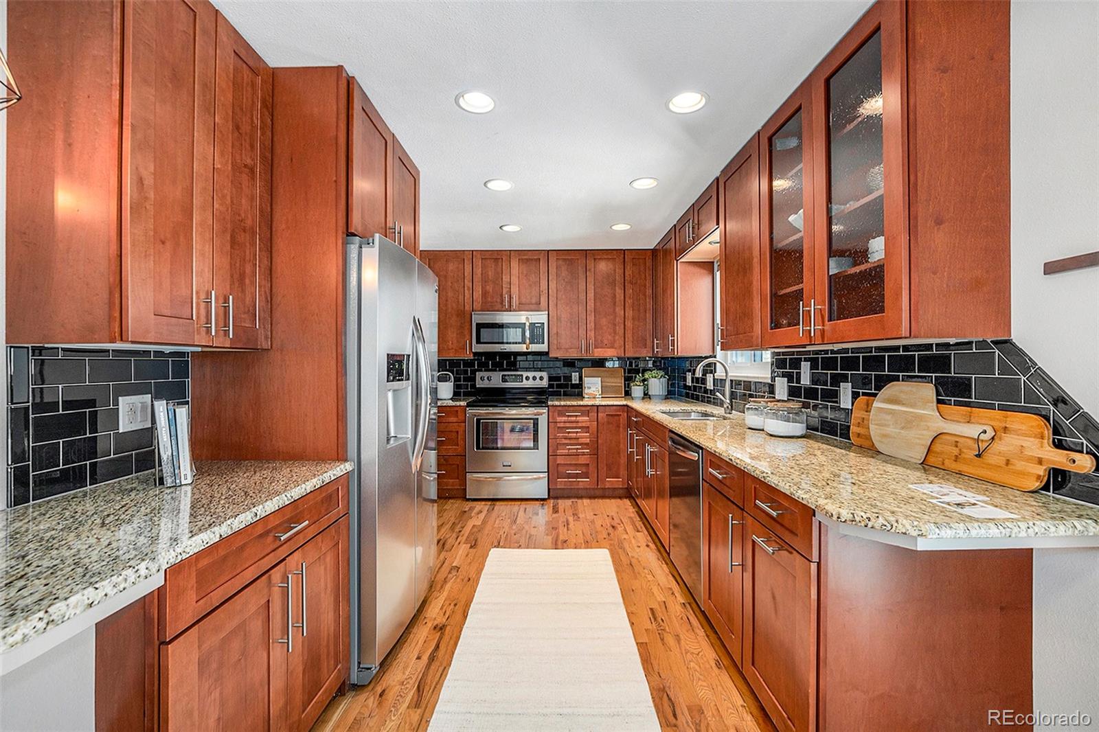 3582 Wright Street Wheat Ridge, CO 80033 - Photo 11 of 31 a large kitchen with stainless steel appliances granite countertop a stove a sink and a microwave