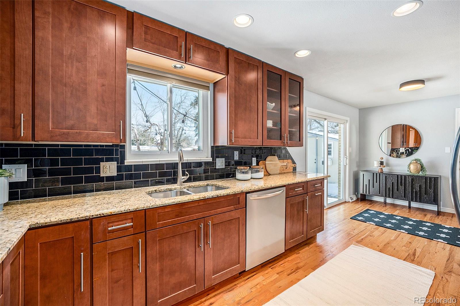 3582 Wright Street Wheat Ridge, CO 80033 - Photo 12 of 31 a large kitchen with stainless steel appliances granite countertop a sink and a wooden cabinets