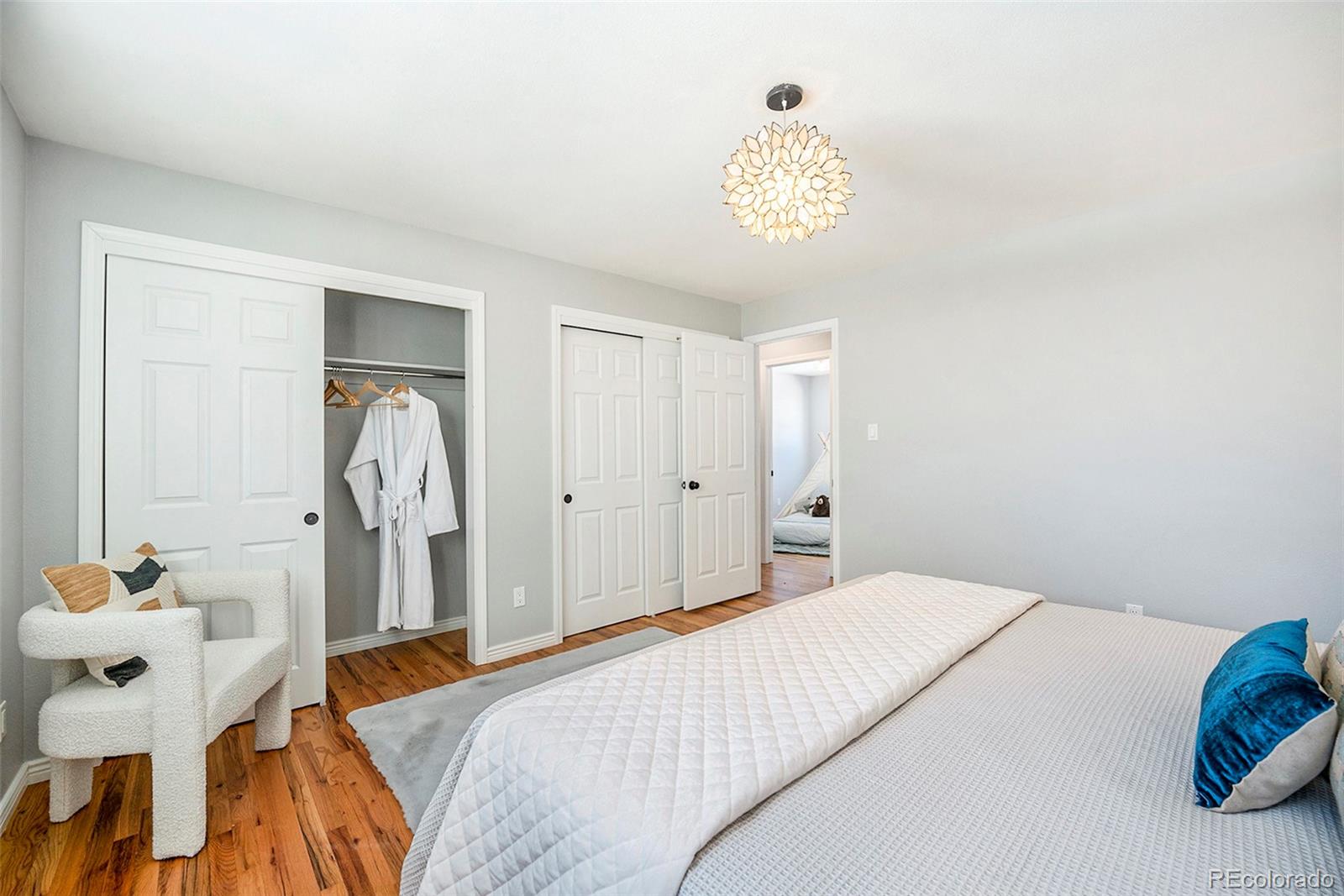 3582 Wright Street Wheat Ridge, CO 80033 - Photo 16 of 31 a bedroom with a bed and a chandelier