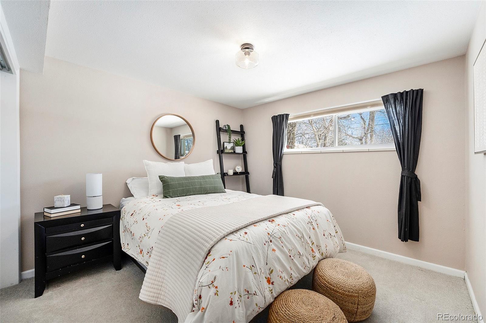 3582 Wright Street Wheat Ridge, CO 80033 - Photo 22 of 31 a bedroom with a bed and a chandelier