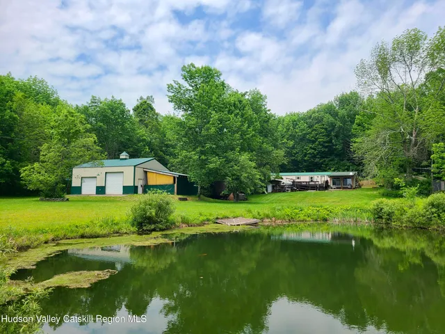 a front view of a house with a yard and lake view