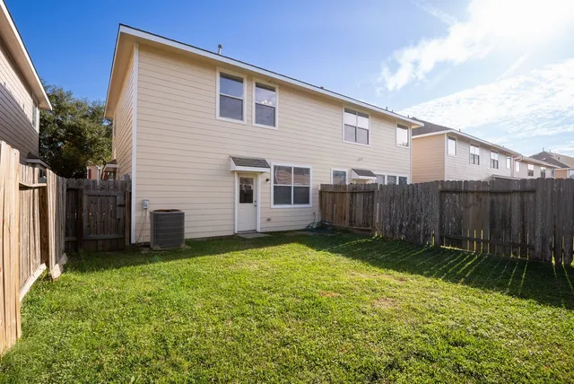 a view of a backyard with plants and brick wall
