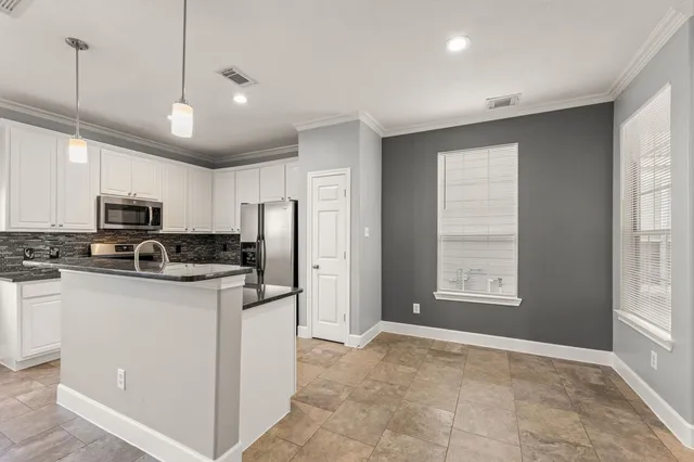 a kitchen with stainless steel appliances granite countertop a refrigerator a stove a sink and a microwave