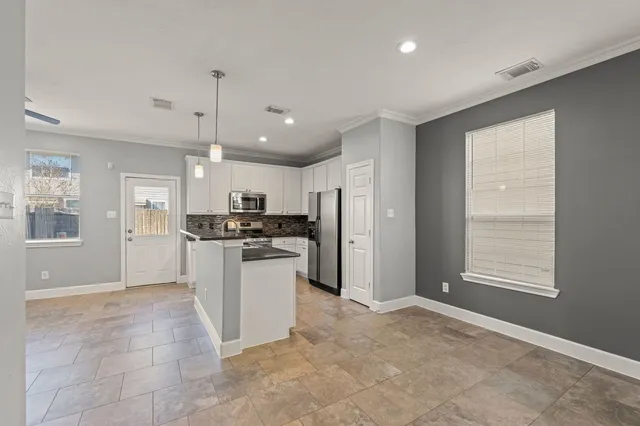 a large kitchen with cabinets and stainless steel appliances