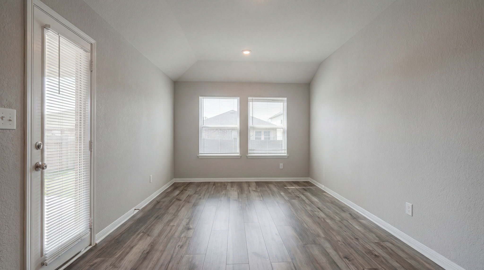 1003 Round Bale Road Hutto, TX 78634 - Photo 25 of 29 Unfurnished room with lofted ceiling, dark wood-style floors, and a textured wall