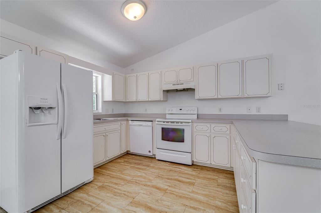 729 Longfellow Terrace Inverness, FL 34450 - Photo 10 of 37 a kitchen with white cabinets and white appliances