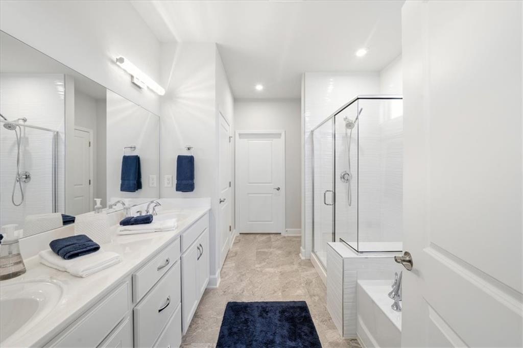 2457 Naples Street Hoschton, GA 30548 - Photo 19 of 41 a bathroom with a double vanity sink a mirror and shower