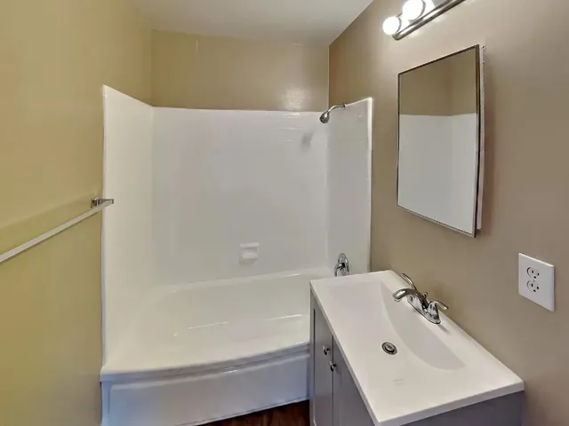 a view of an empty room with glass door and wooden floor