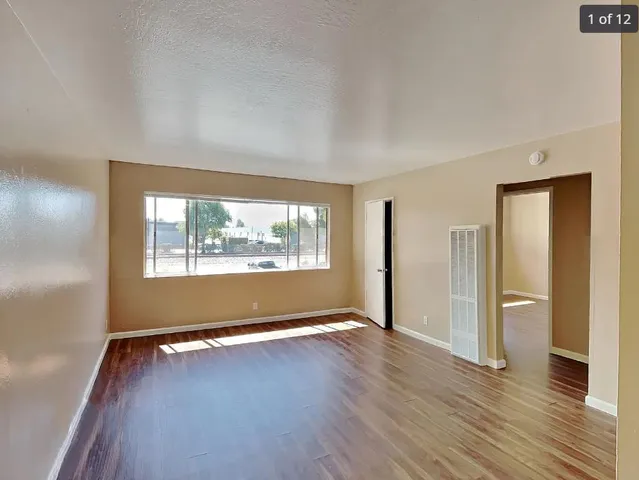 a view of kitchen with refrigerator and wooden floor