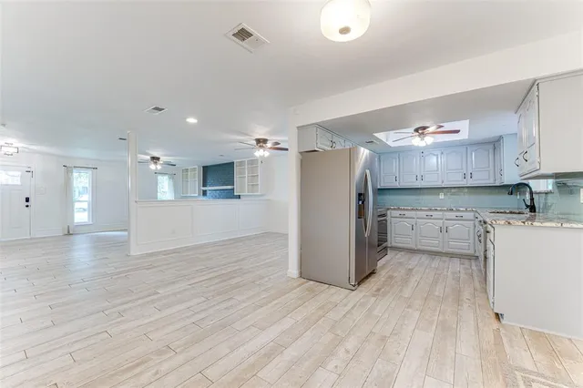 a view of a kitchen with a sink and wooden floor