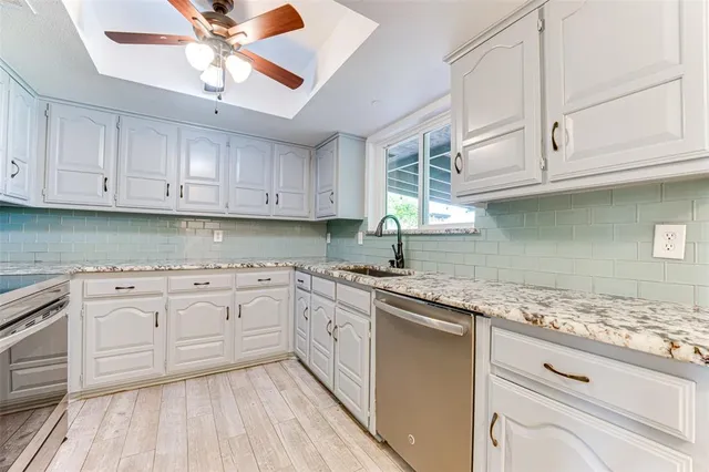 a kitchen with granite countertop cabinets stainless steel appliances and a sink