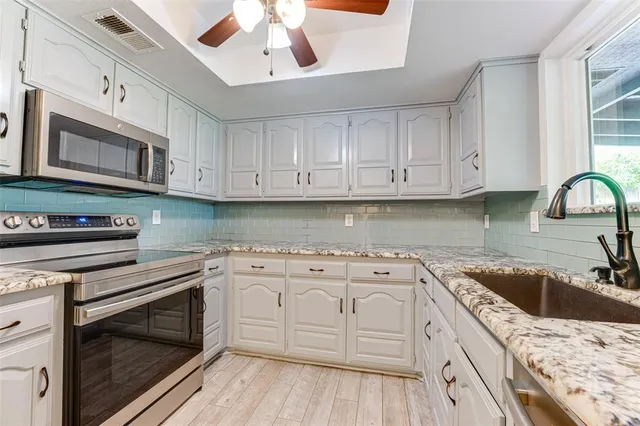 a kitchen with stainless steel appliances granite countertop a stove sink and cabinets