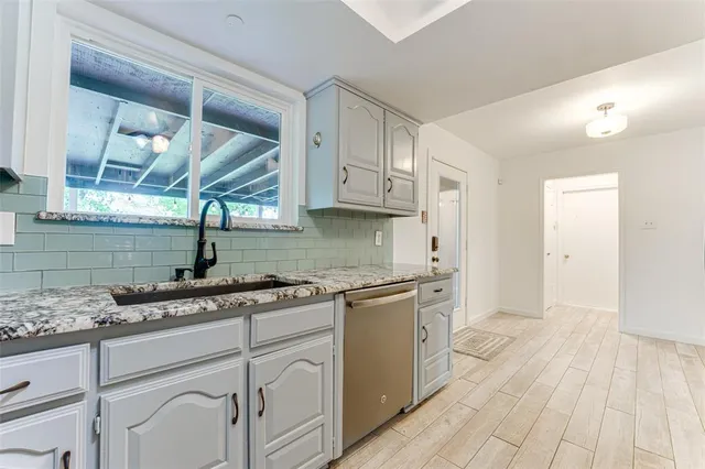 a kitchen with granite countertop white cabinets and white appliances
