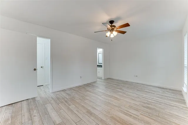 a view of a room with a ceiling fan and wooden floor
