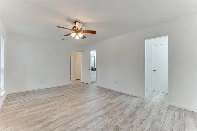 a view of a room with wooden floor and a ceiling fan