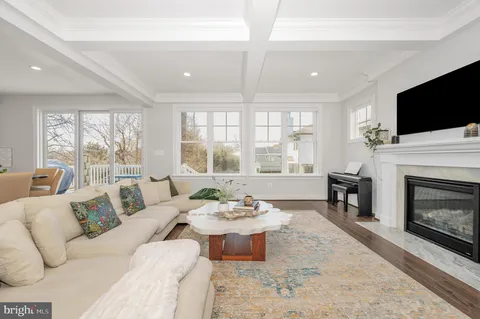 a kitchen with a dining table chairs wooden floor cabinets and appliances