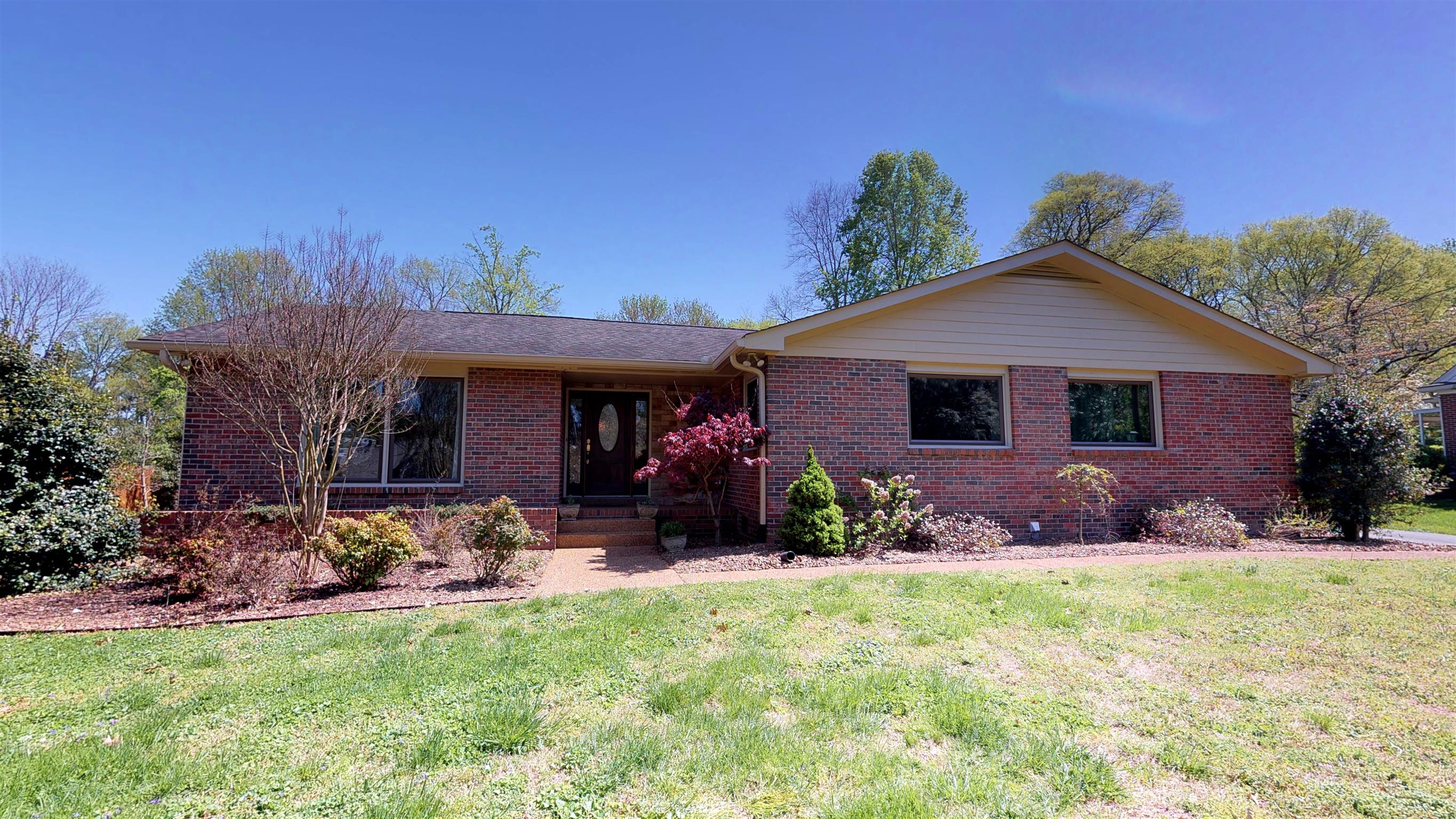 a front view of a house with yard and green space