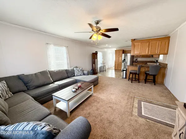 a living room with furniture ceiling fan and a window