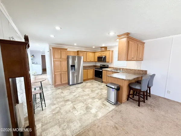 a view of kitchen with refrigerator stove dining table and chairs