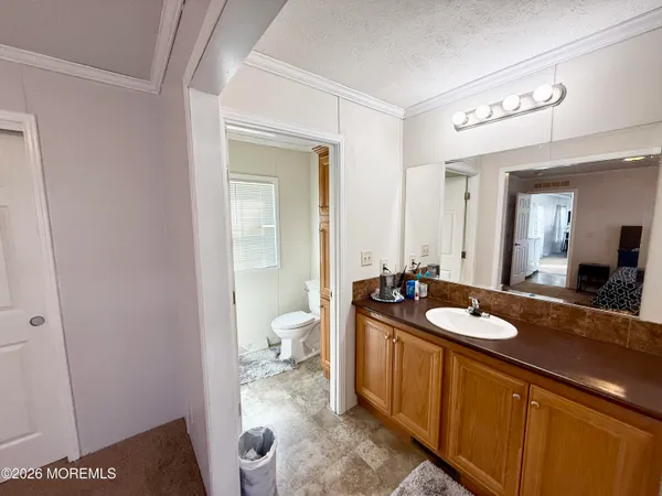 a spacious bathroom with a granite countertop sink and a mirror