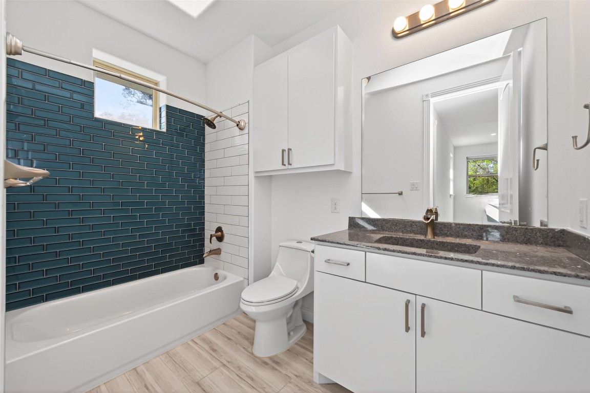 2504 Southline Road Conroe, TX 77384 - Photo 20 of 26 a bathroom with a granite countertop toilet a sink and bathtub