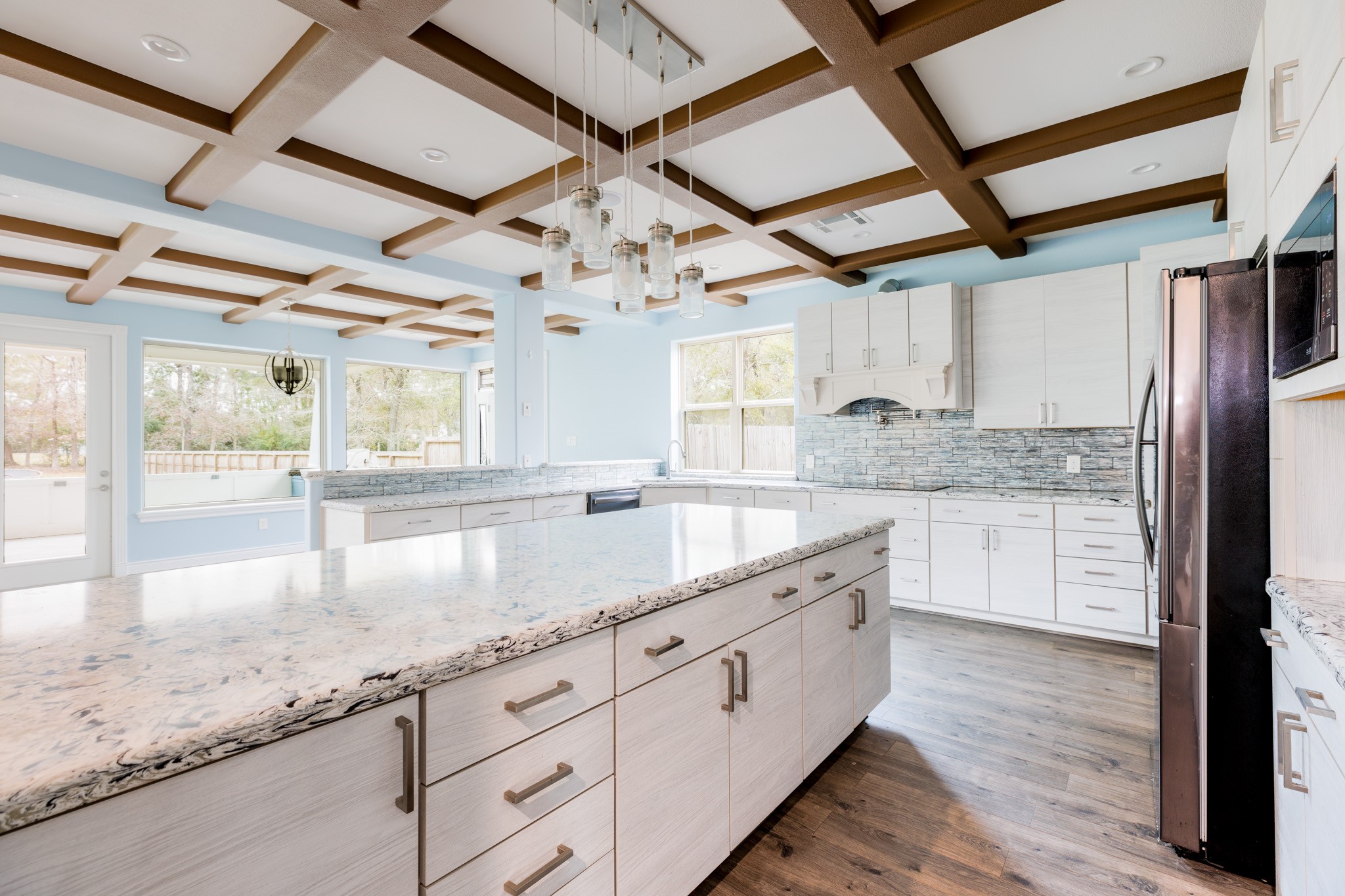 2504 Southline Road Conroe, TX 77384 - Photo 6 of 20 a large kitchen with kitchen island granite countertop a sink window and stainless steel appliances
