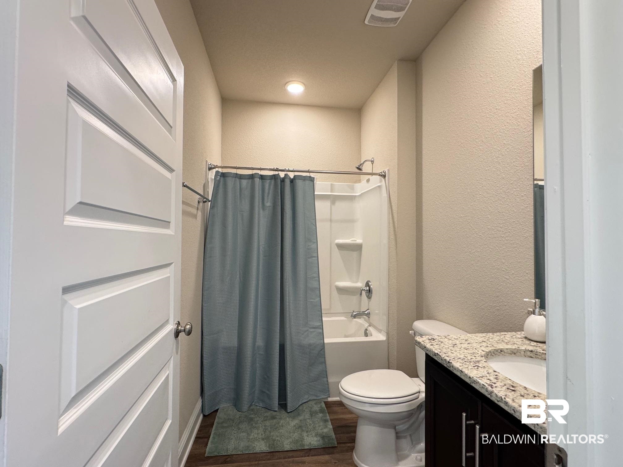 1346 Kairos Loop Foley, AL 36535 - Photo 21 of 40 Full bathroom with toilet, vanity, shower / tub combo, and hardwood / wood-style flooring