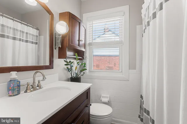 a bathroom with a sink a toilet and a mirror