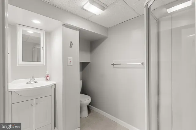 a bathroom with a sink a toilet a shower and a mirror