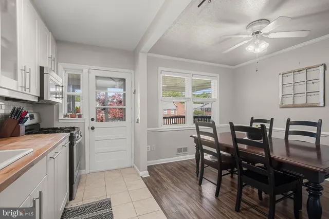 a kitchen with a table chairs and white cabinets