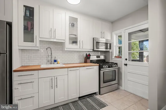 a kitchen with white cabinets and stainless steel appliances
