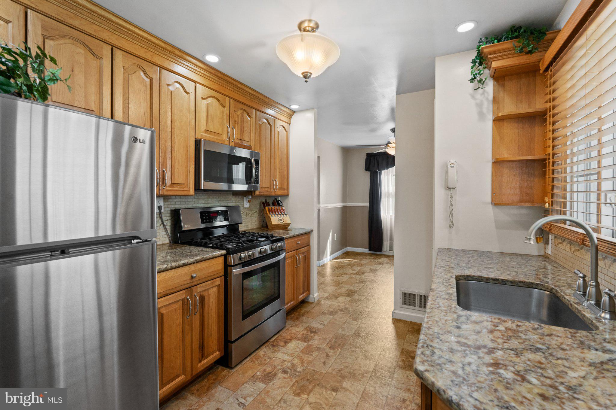 945 Homberg Avenue Baltimore, MD 21221 - Photo 9 of 27 a kitchen with granite countertop a refrigerator stove and sink