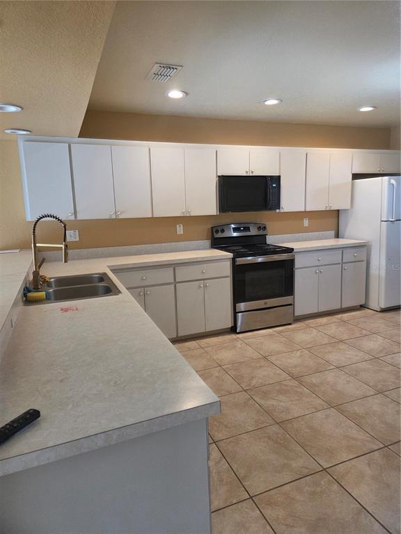 4532 Great Blue Heron Drive Lakeland, FL 33812 - Photo 16 of 33 a kitchen with a sink a stove and cabinets