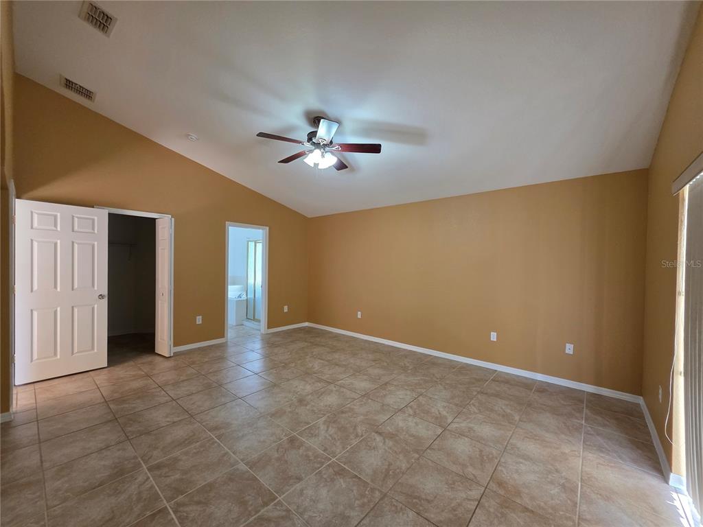 4532 Great Blue Heron Drive Lakeland, FL 33812 - Photo 19 of 33 a view of an empty room with a chandelier fan and windows