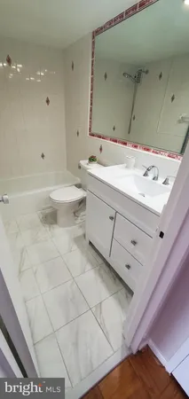 a bathroom with a sink vanity granite and a toilet
