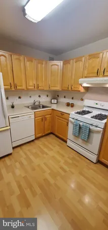a large kitchen with stainless steel appliances a stove a sink and a microwave